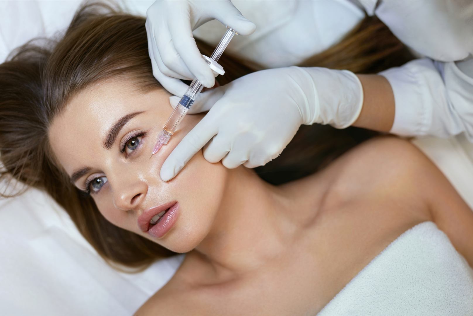 A woman is getting a botox injection in her face.