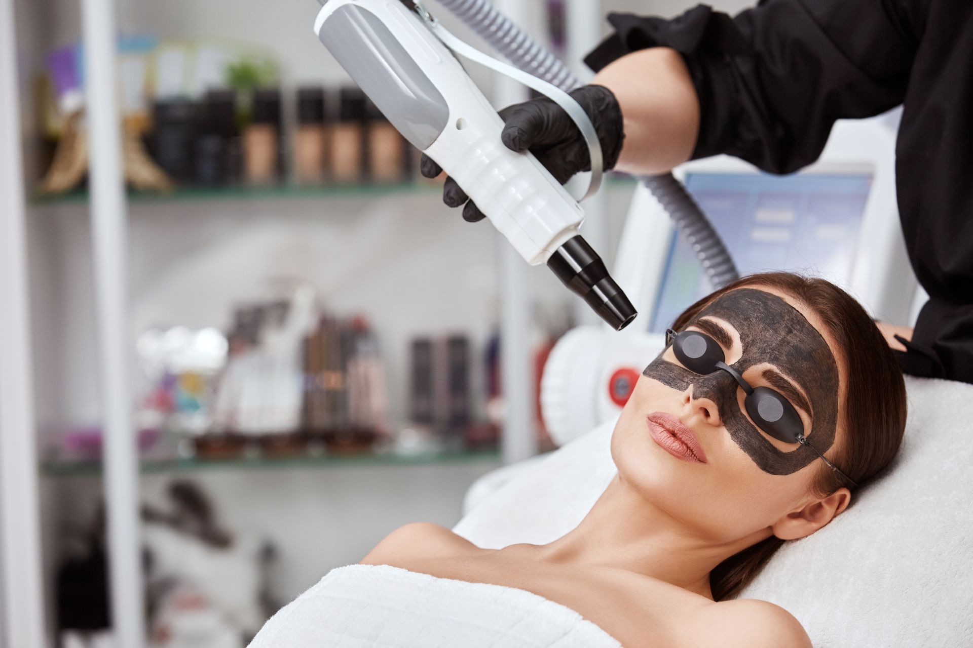 a woman is getting a black mask on her face in a beauty salon .