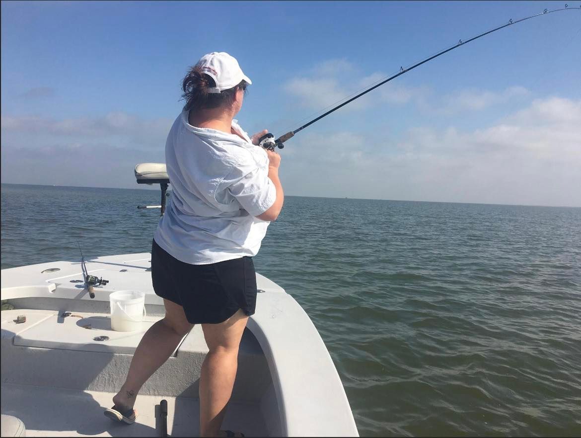 A woman is fishing on a boat in the ocean