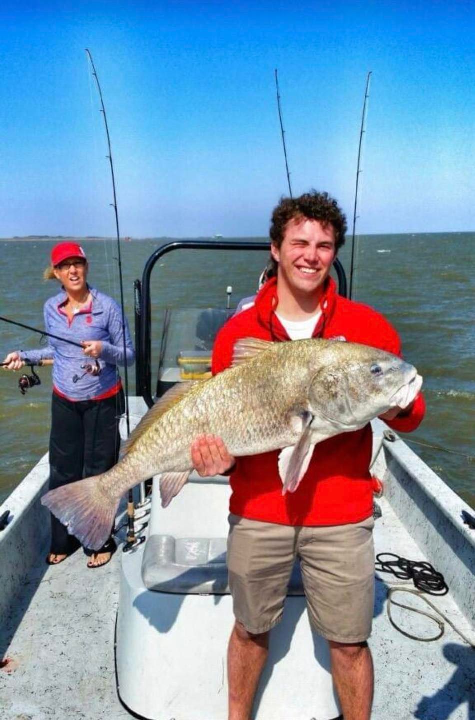 A man is holding a large fish on a boat