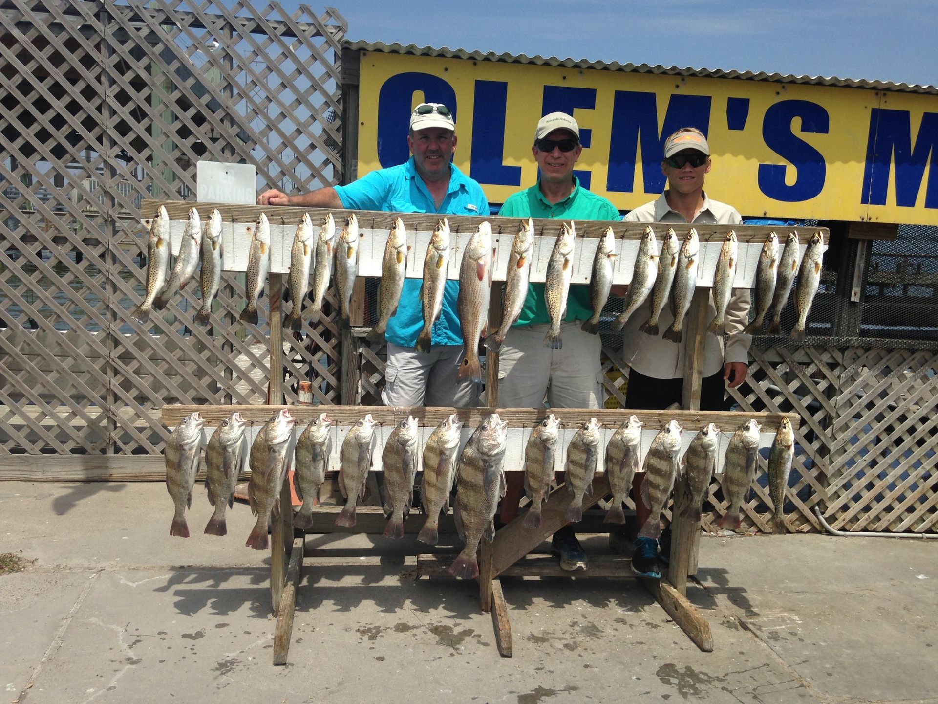 Three men standing in front of a sign that says glen 's