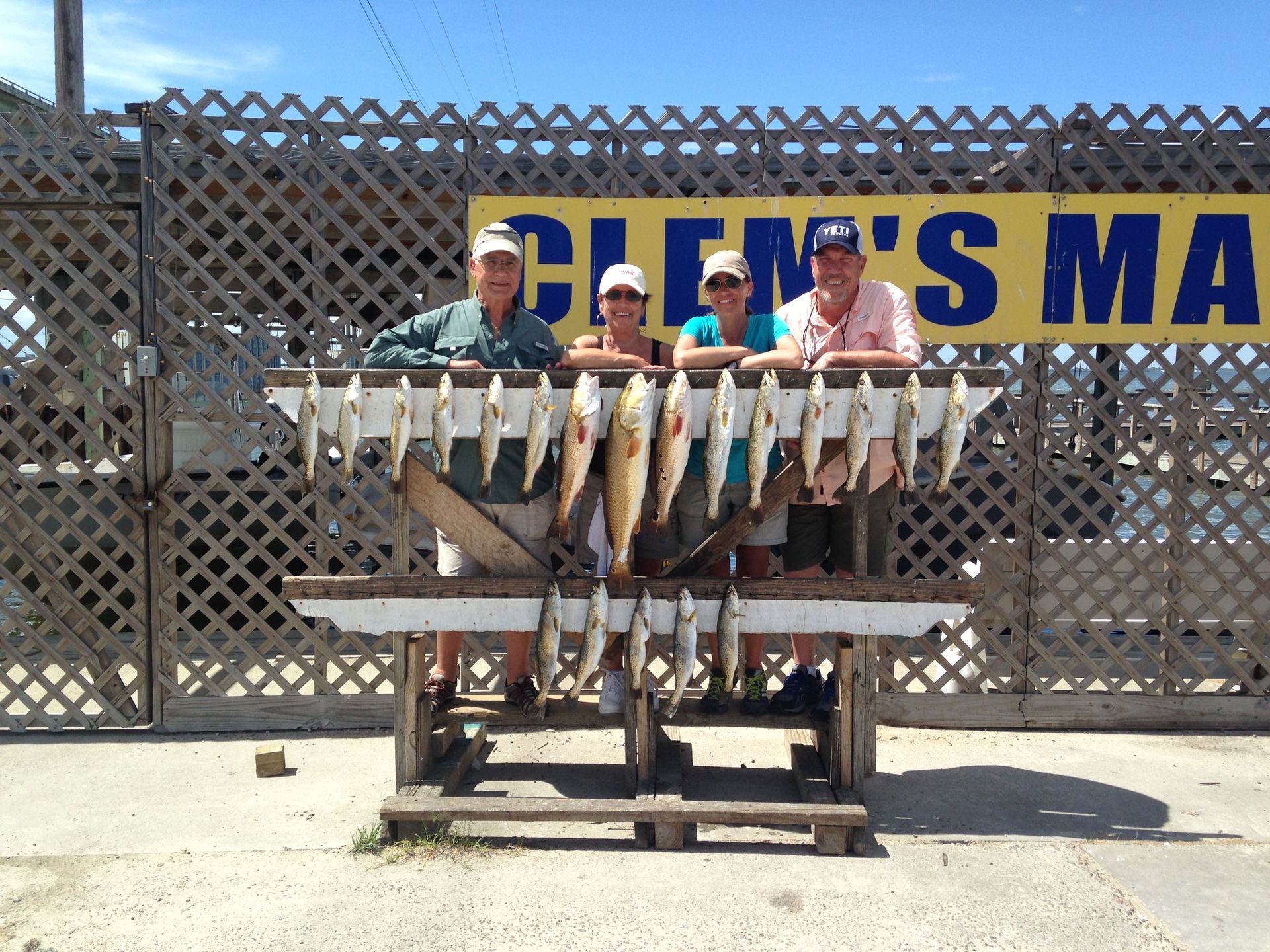 A group of people standing in front of a sign that says clem 's marina