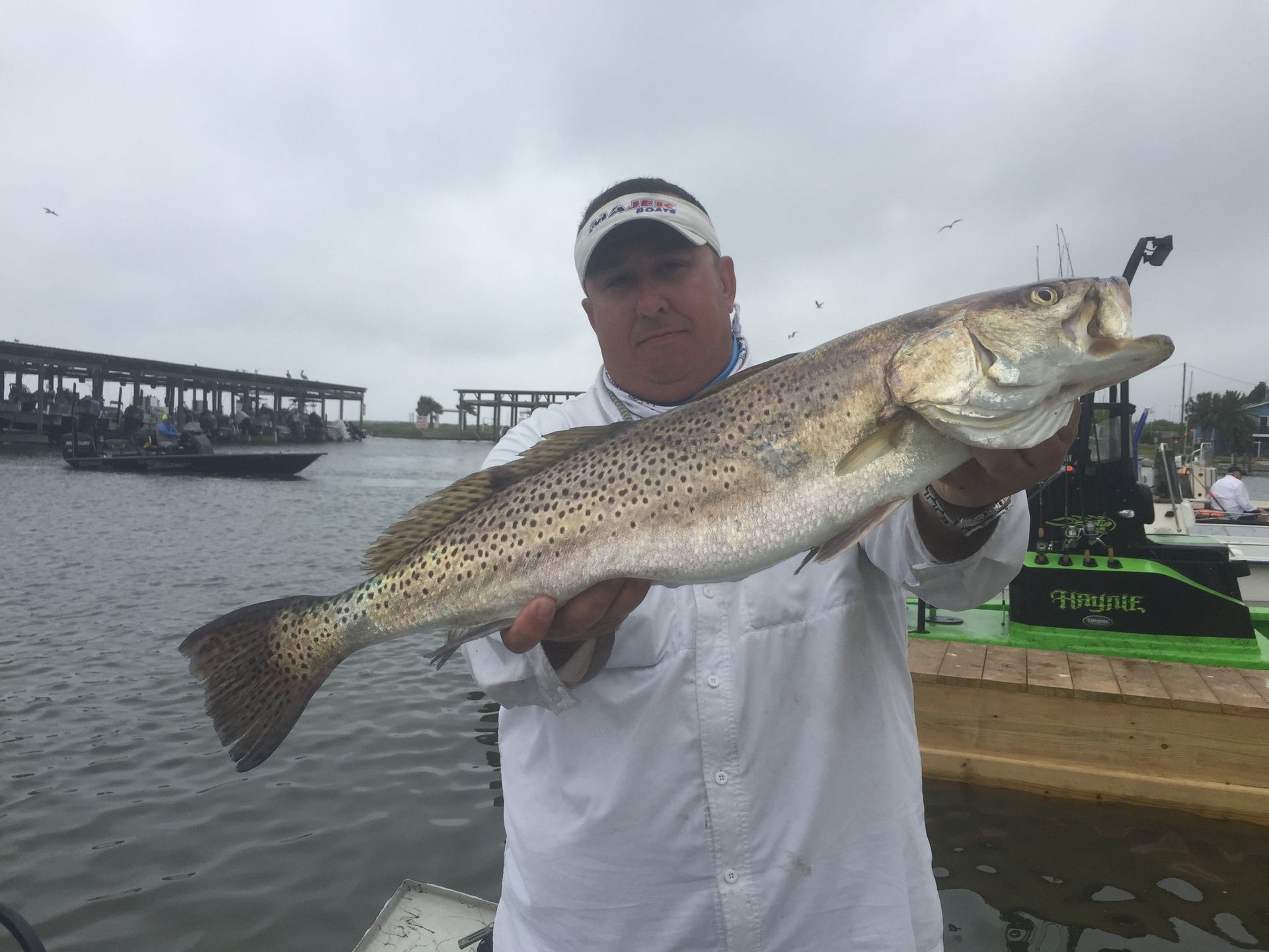 A man is holding a large fish in his hands in the water.