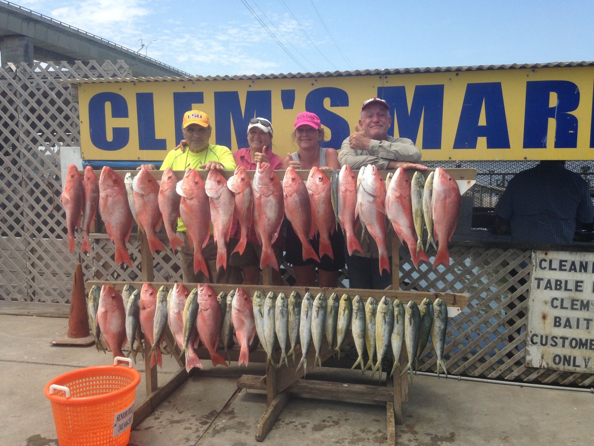 A group of people standing in front of a sign that says clem 's marina
