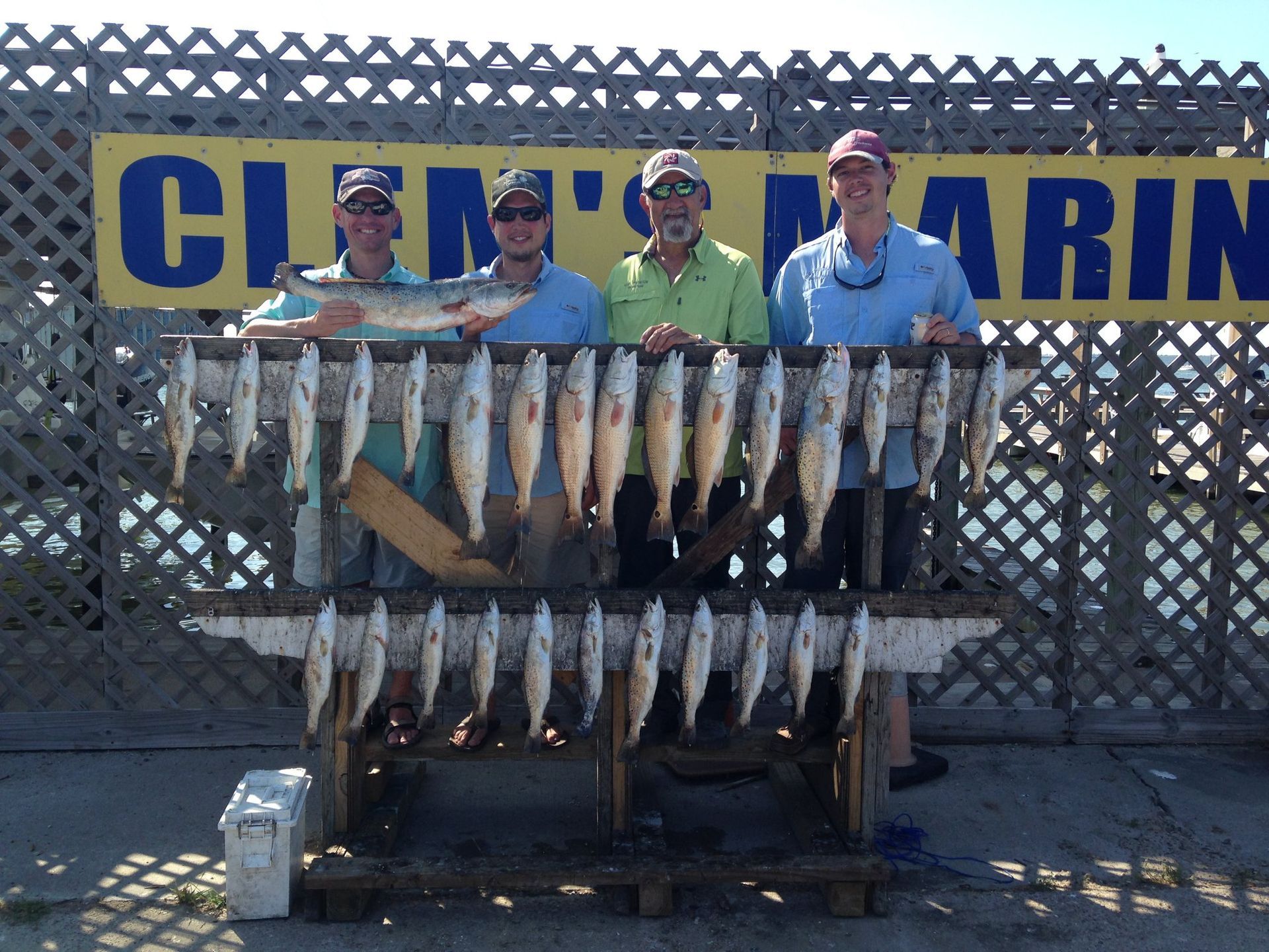 A group of men standing in front of a sign that says glen 's marina