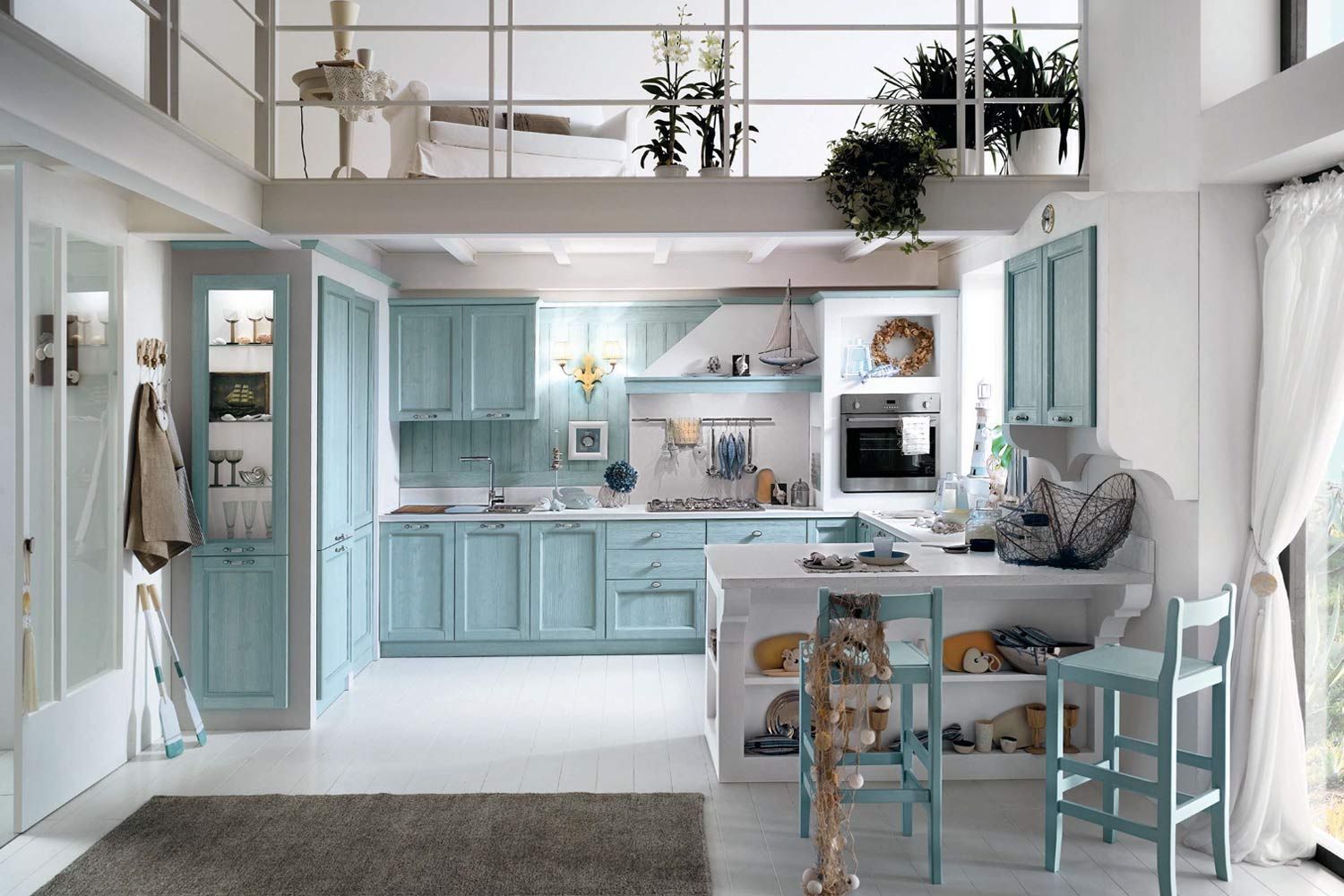 Cucina azzurra con dettagli bianchi, soppalco e tappeto grigio.