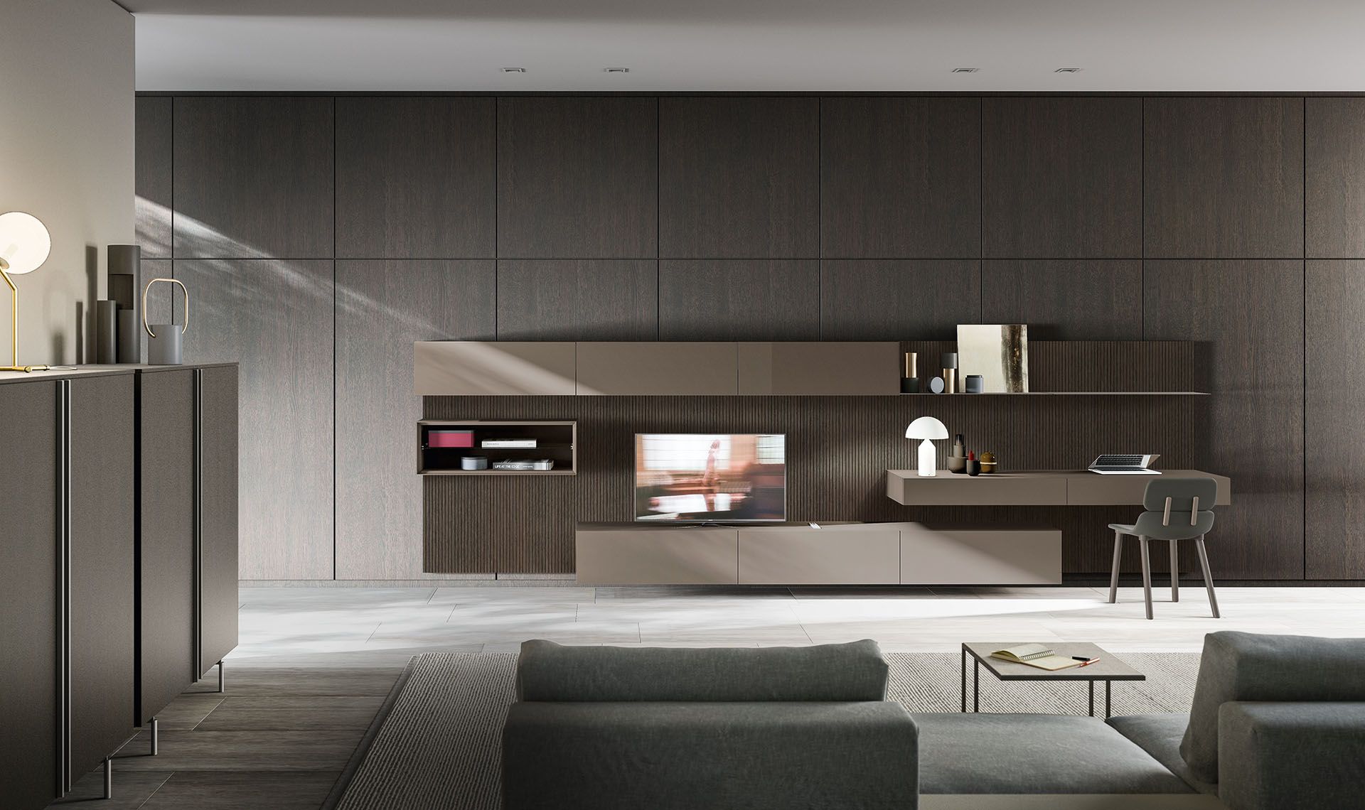 Soggiorno moderno con mobili integrati, scrivania, TV e divano componibile grigio.