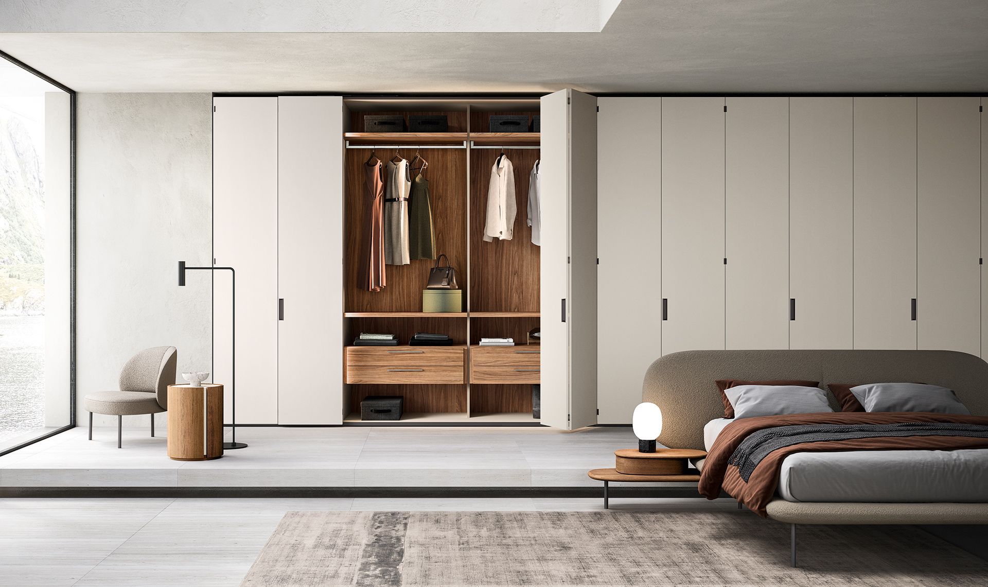 Camera da letto moderna con ampio armadio, dettagli in legno, colori neutri e un letto con cuscini decorativi e una coperta.