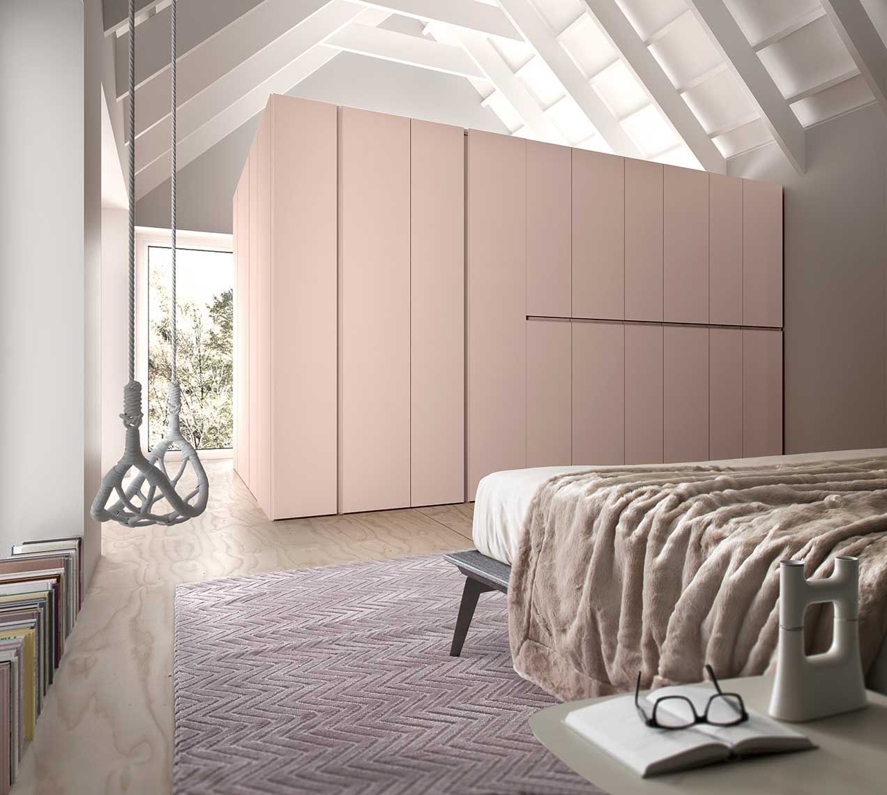 Camera da letto con armadio rosa, un letto, una finestra con un'altalena e un tappeto.