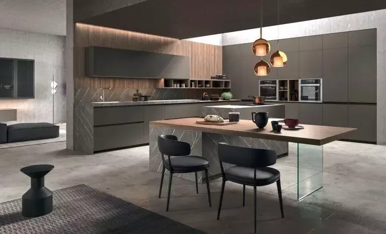 Cucina moderna con mobili grigi, dettagli in legno, isola con posti a sedere e lampade a sospensione.