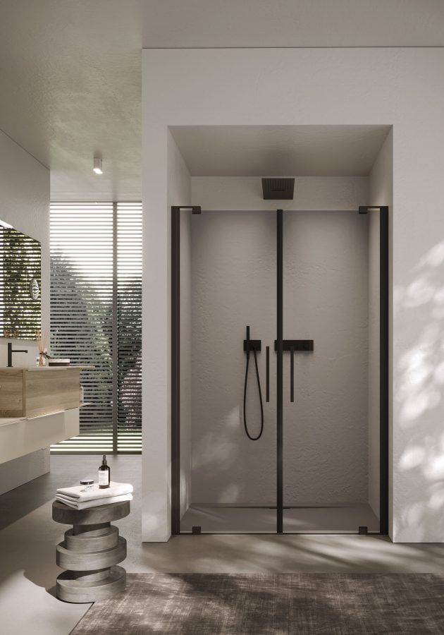 Doccia moderna con porte in vetro con cornice nera, sanitari neri e interni piastrellati di colore chiaro.