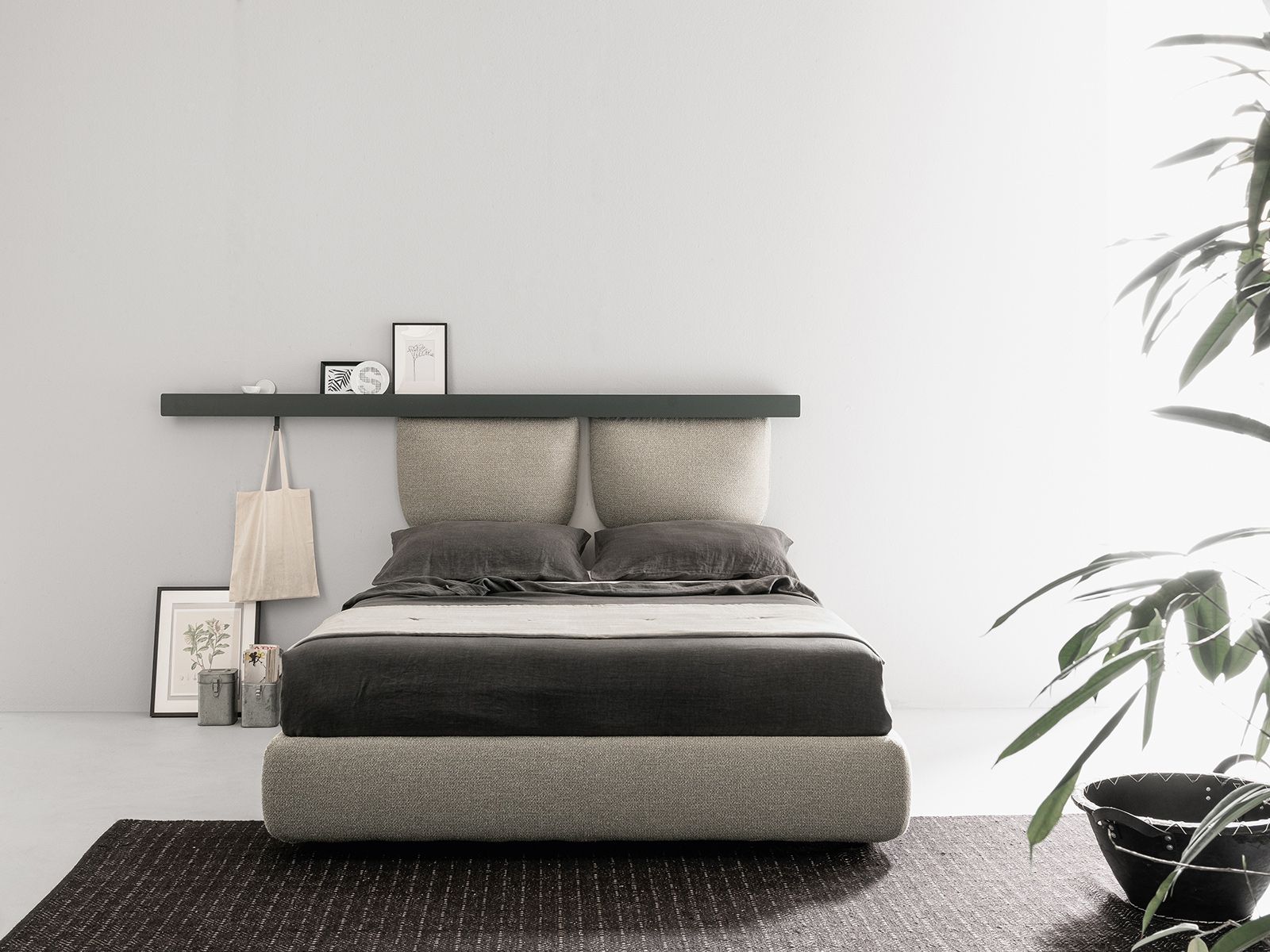 Camera da letto moderna con letto imbottito, mensola sospesa con decorazioni e una pianta.