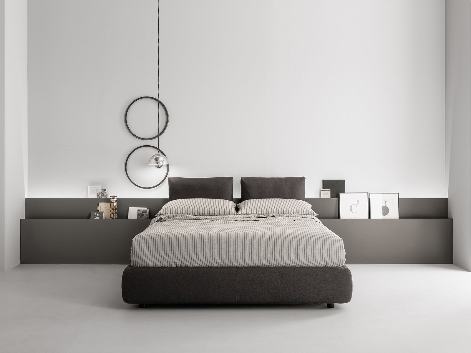 Camera da letto moderna con letto, testiera, specchi e mensola. Combinazione di colori grigio e bianco.