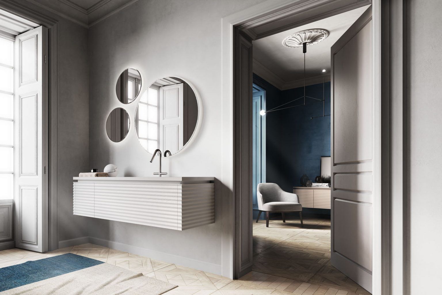 Bagno moderno con lavandino sospeso, numerosi specchi rotondi e porta che conduce a una zona soggiorno con pareti blu.