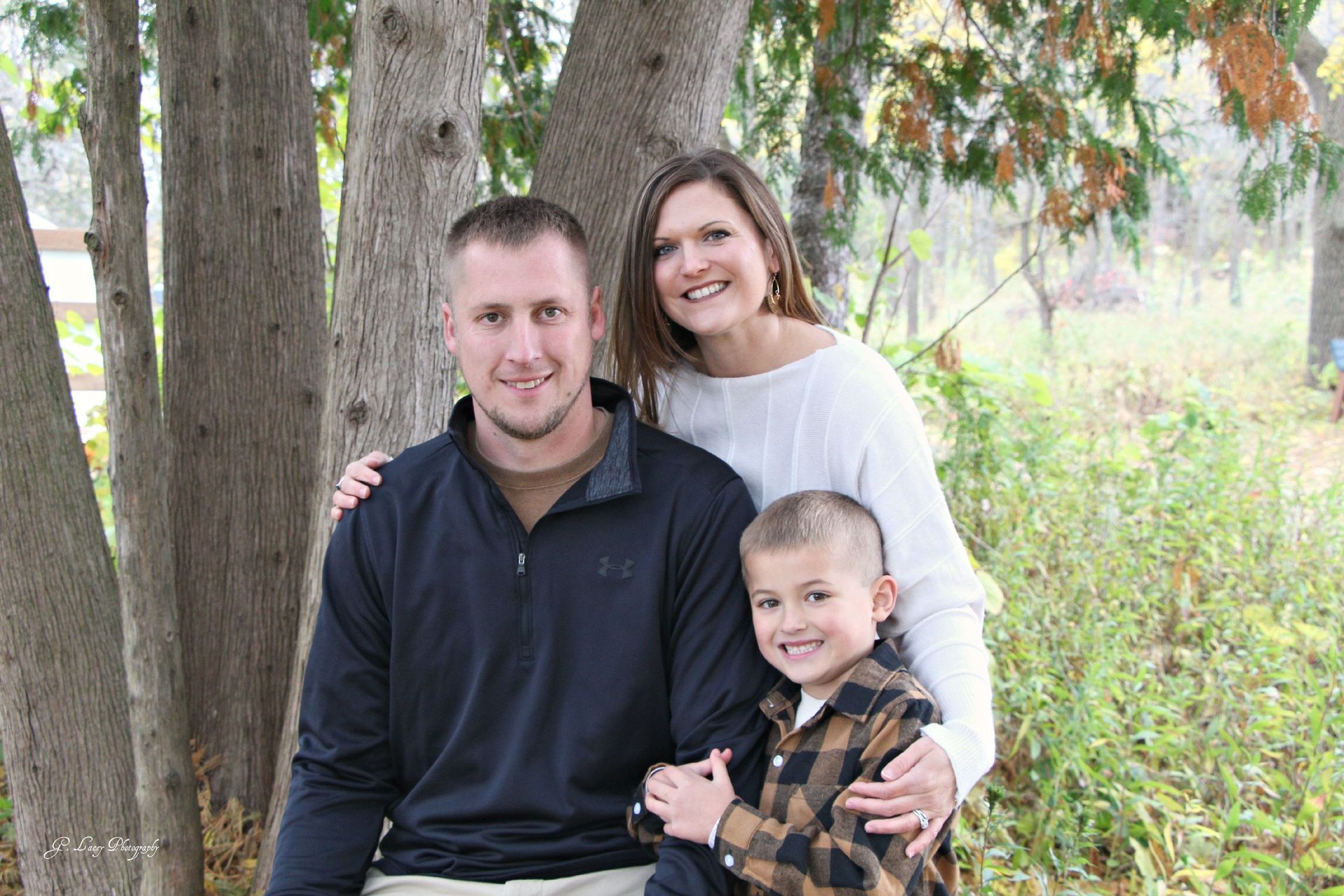 Three people standing in front of a tree