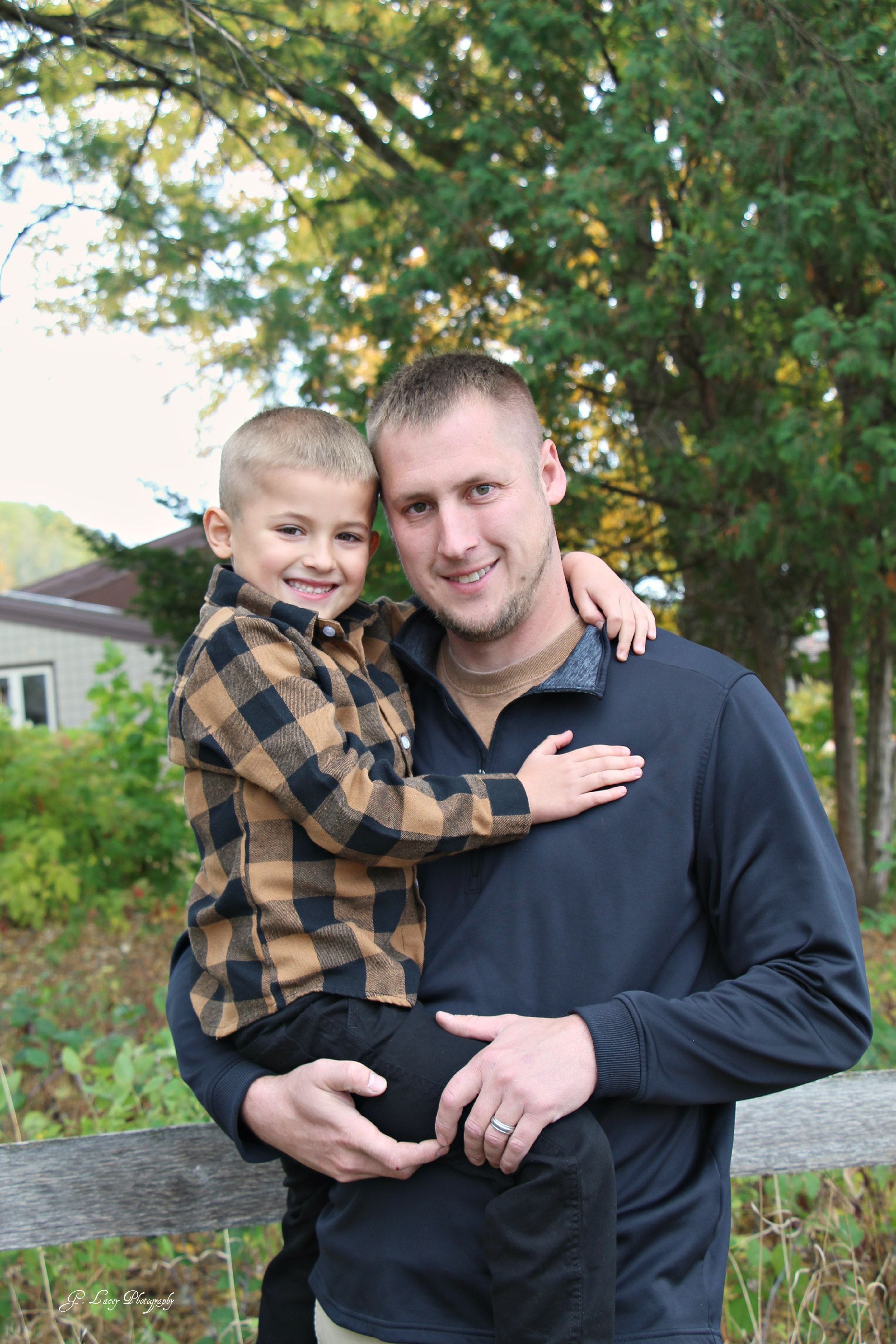 A man is holding a little boy in his arms.