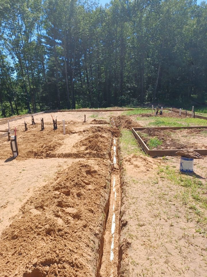 A construction site with a lot of dirt and trees in the background.