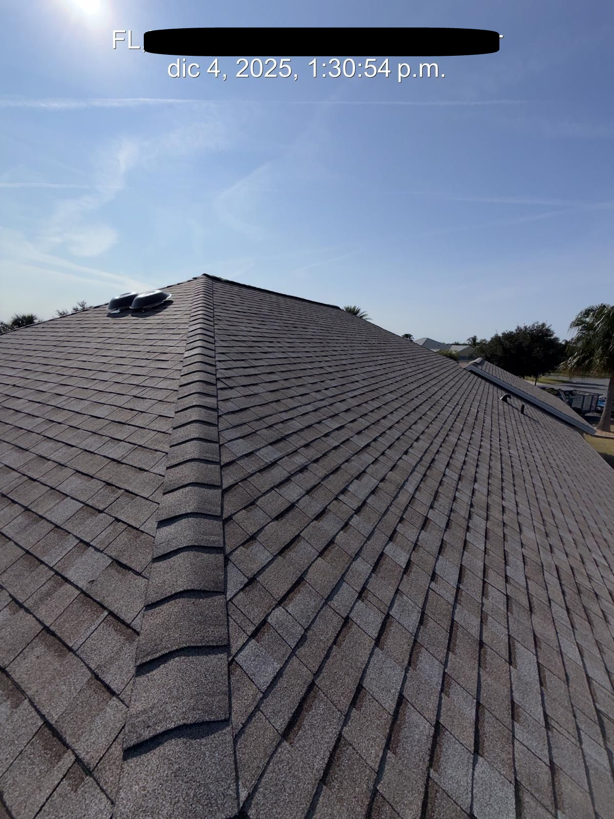 Asphalt shingle roof in Florida showing ridge and ventilation components after installation