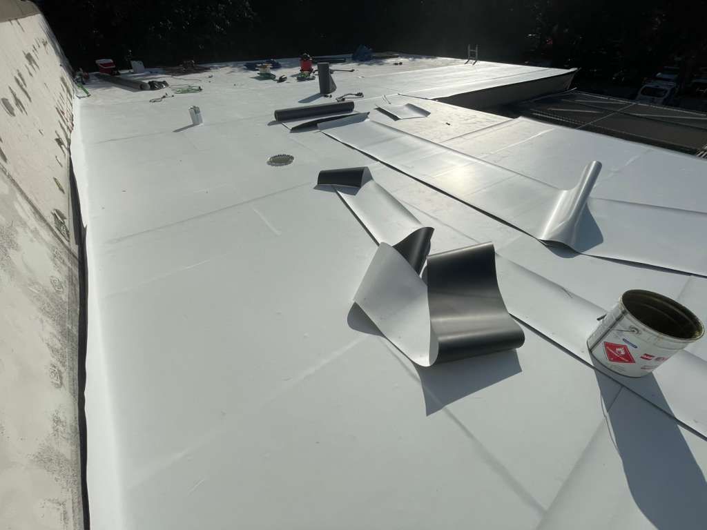 Flat roof installation in Orlando Florida — workers sealing TPO membrane joints for a durable commercial roofing finish.