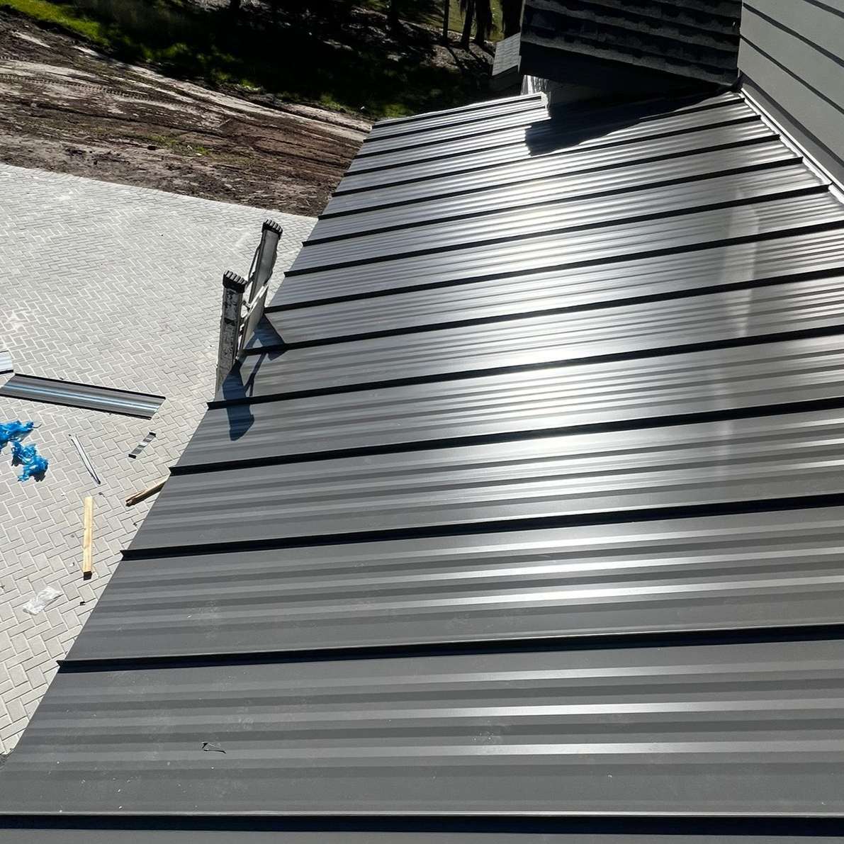Metal roof repair in Florida showing standing seam panels and sealing work — metal roofing cost comparison for 2026 projections.