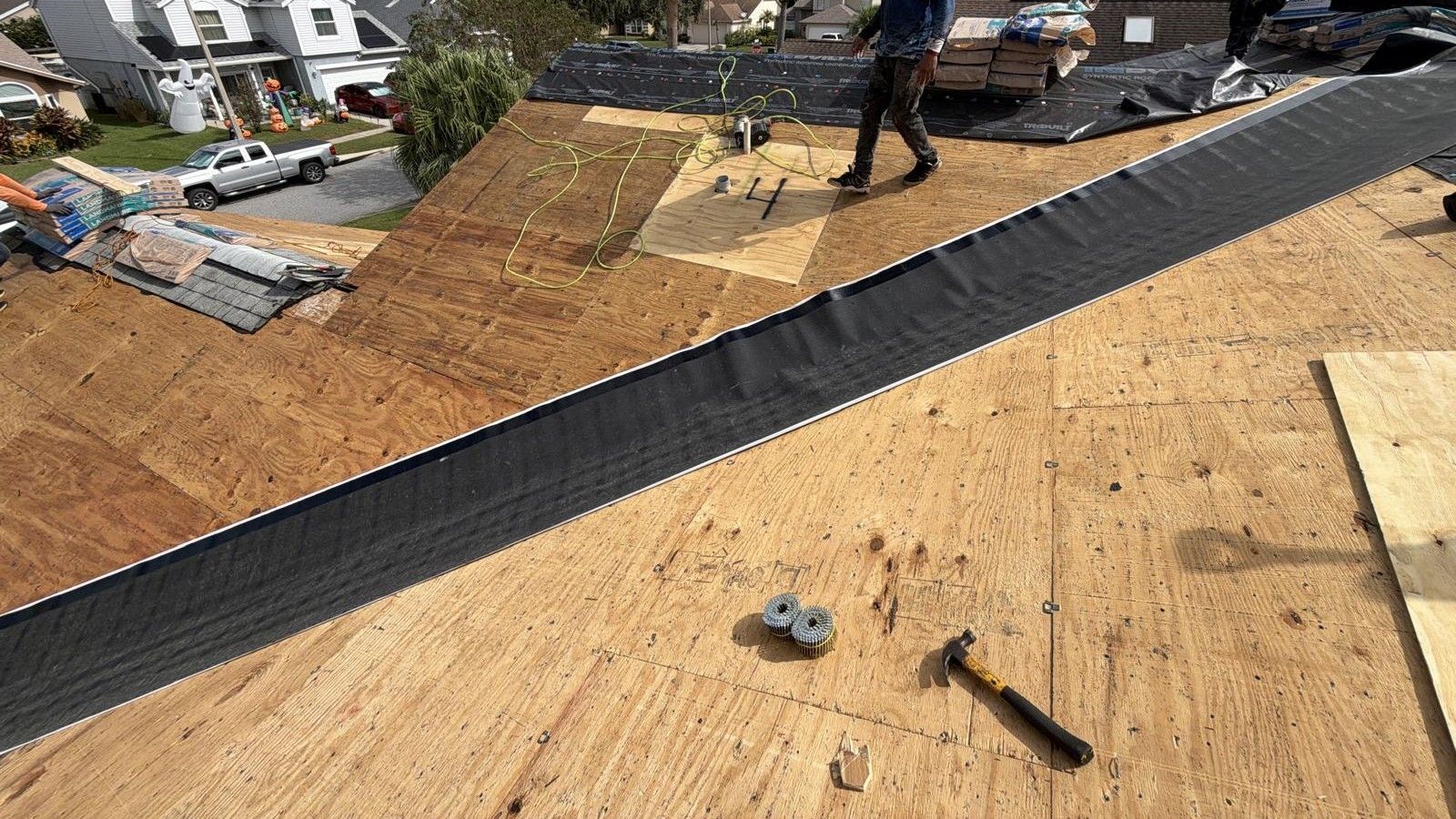 Professional roofing crew installing asphalt shingles on a new residential roof in Orlando, following Florida Building Code and safety standards.