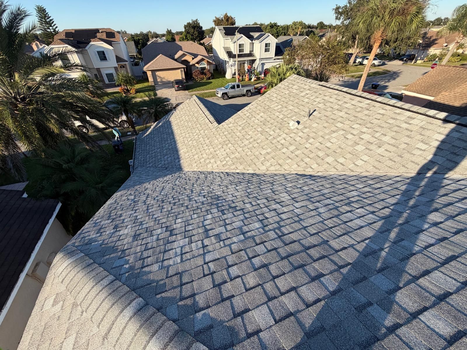 Asphalt shingle roof glistening at sunrise in Orlando, Florida, highlighting completed residential roof replacement designed for long-term weather resistance.