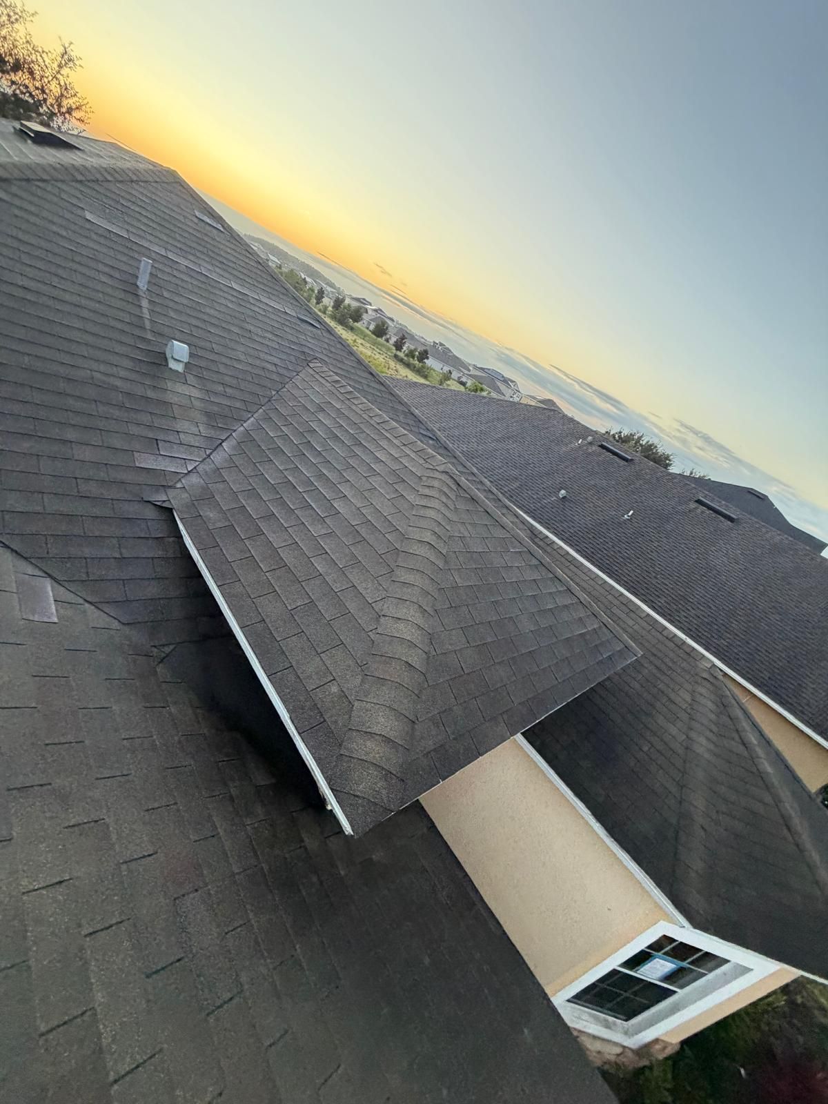 Residential shingle roof installation in Orlando, FL, captured during sunset, showing a fully replaced roof with new architectural shingles.