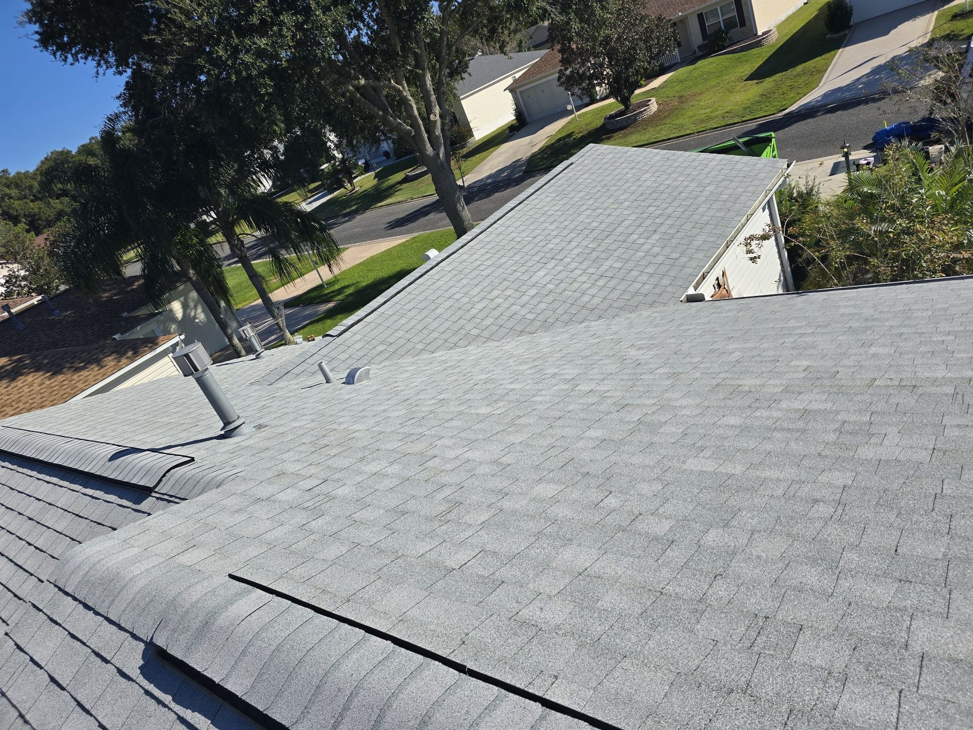 Completed shingle roof installation on Florida home with gray asphalt shingles providing a clean and modern look.