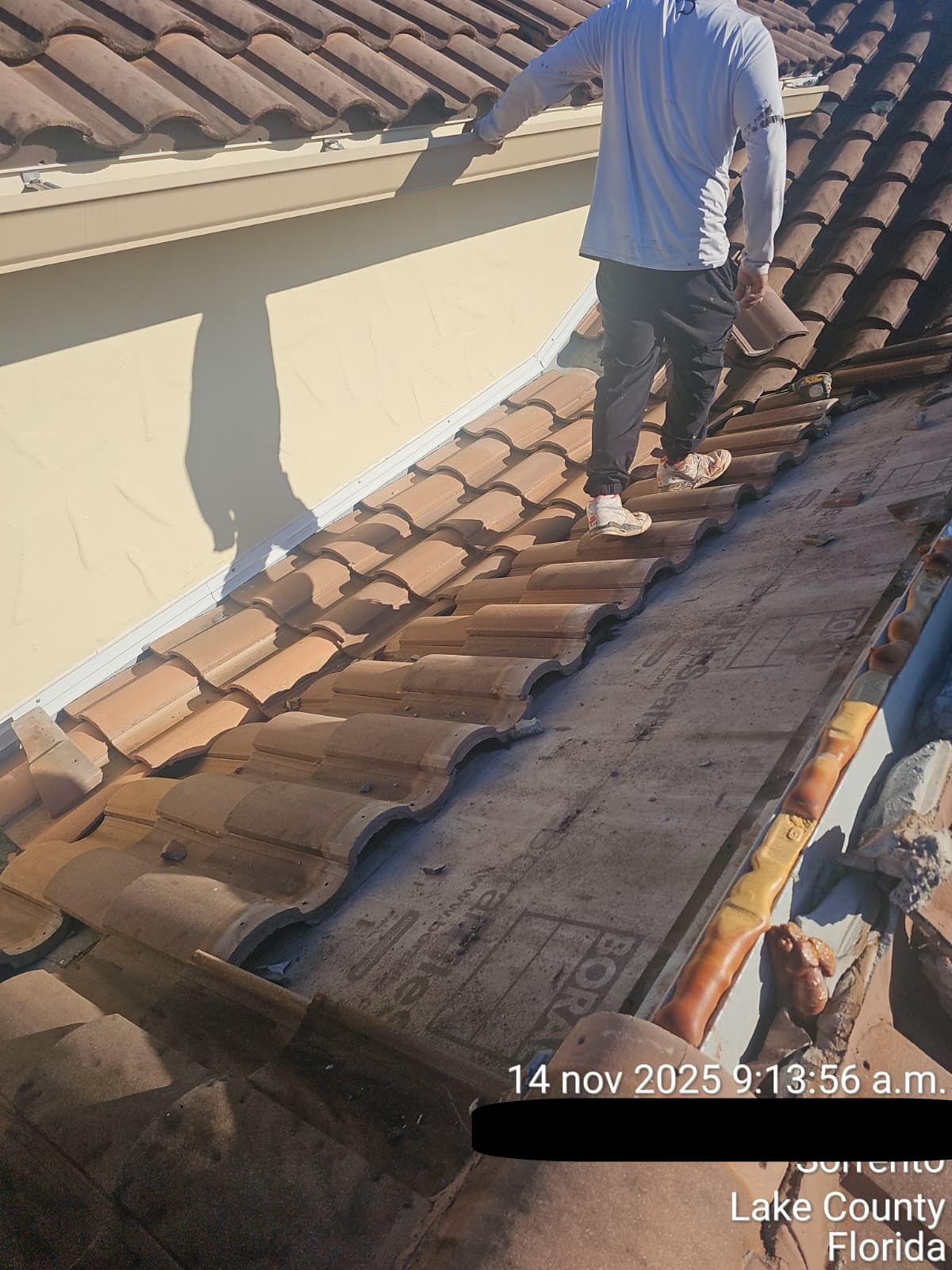 Roofing technician performing storm damage repair of a Tile Roof on a residential home in Kissimmee, Osceola County, Florida, ensuring structural integrity and compliance with Florida Building Code standards.