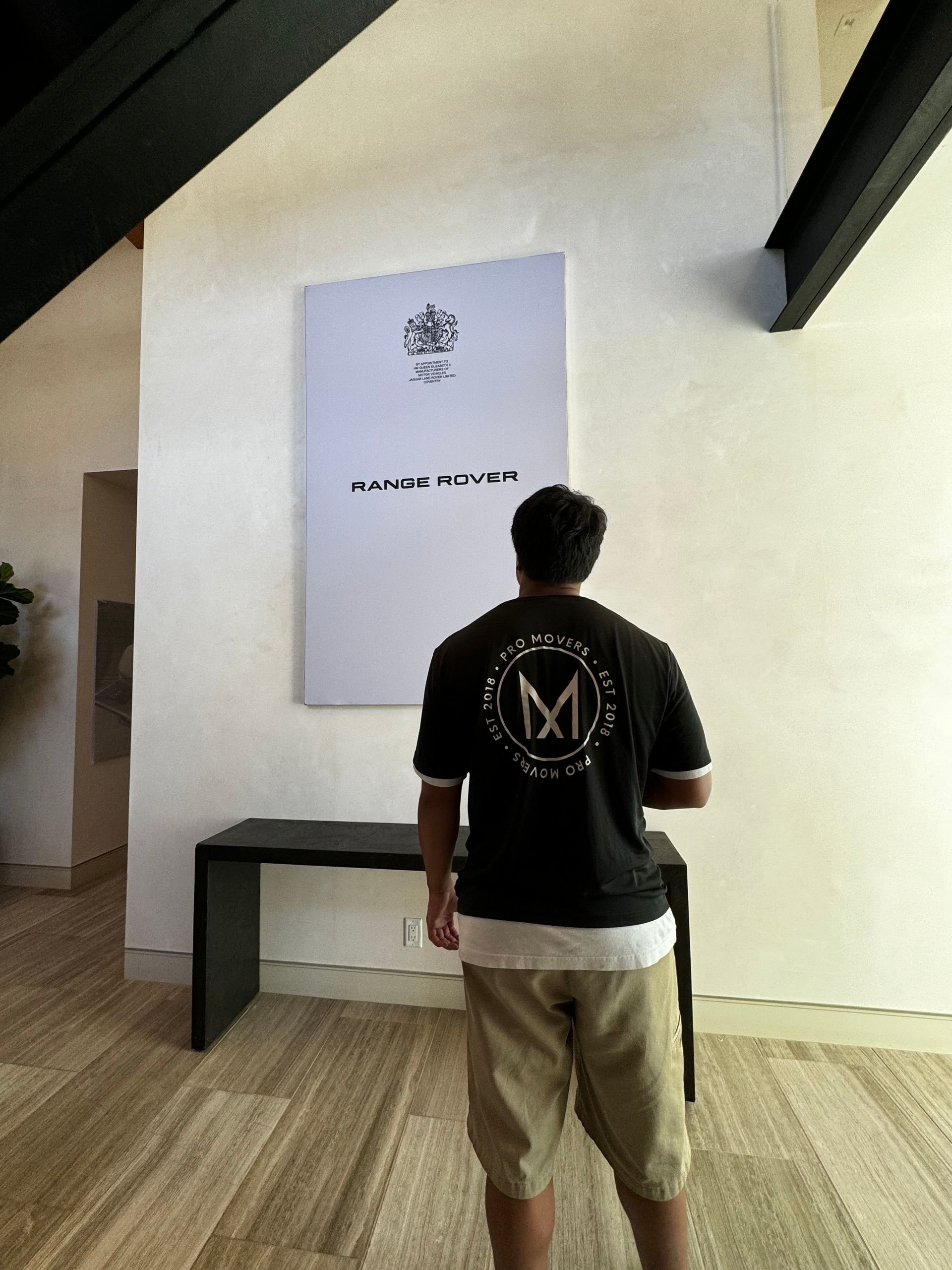 A man wearing a black shirt with the letter m on the back