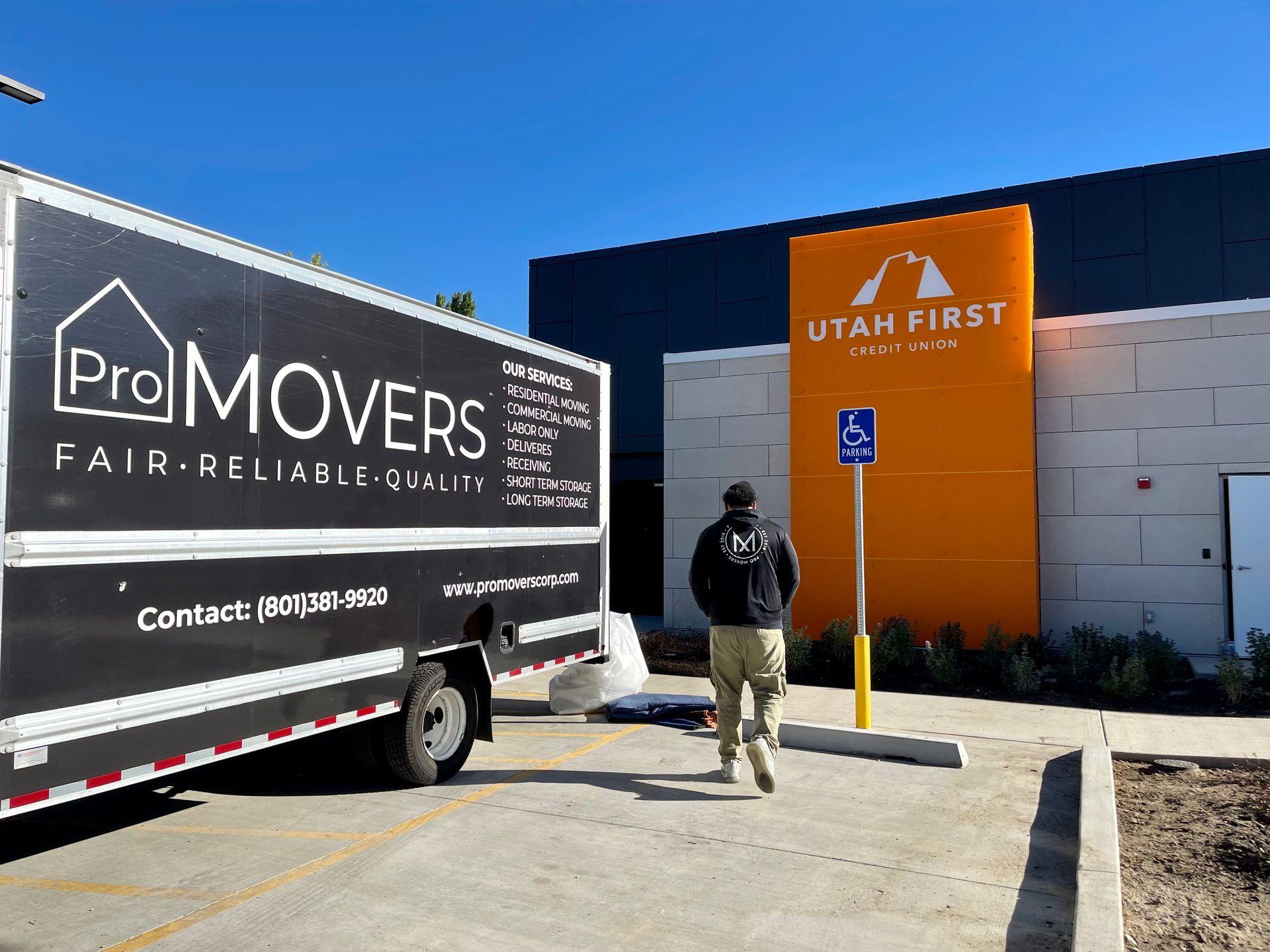 A pro movers truck is parked in front of a building