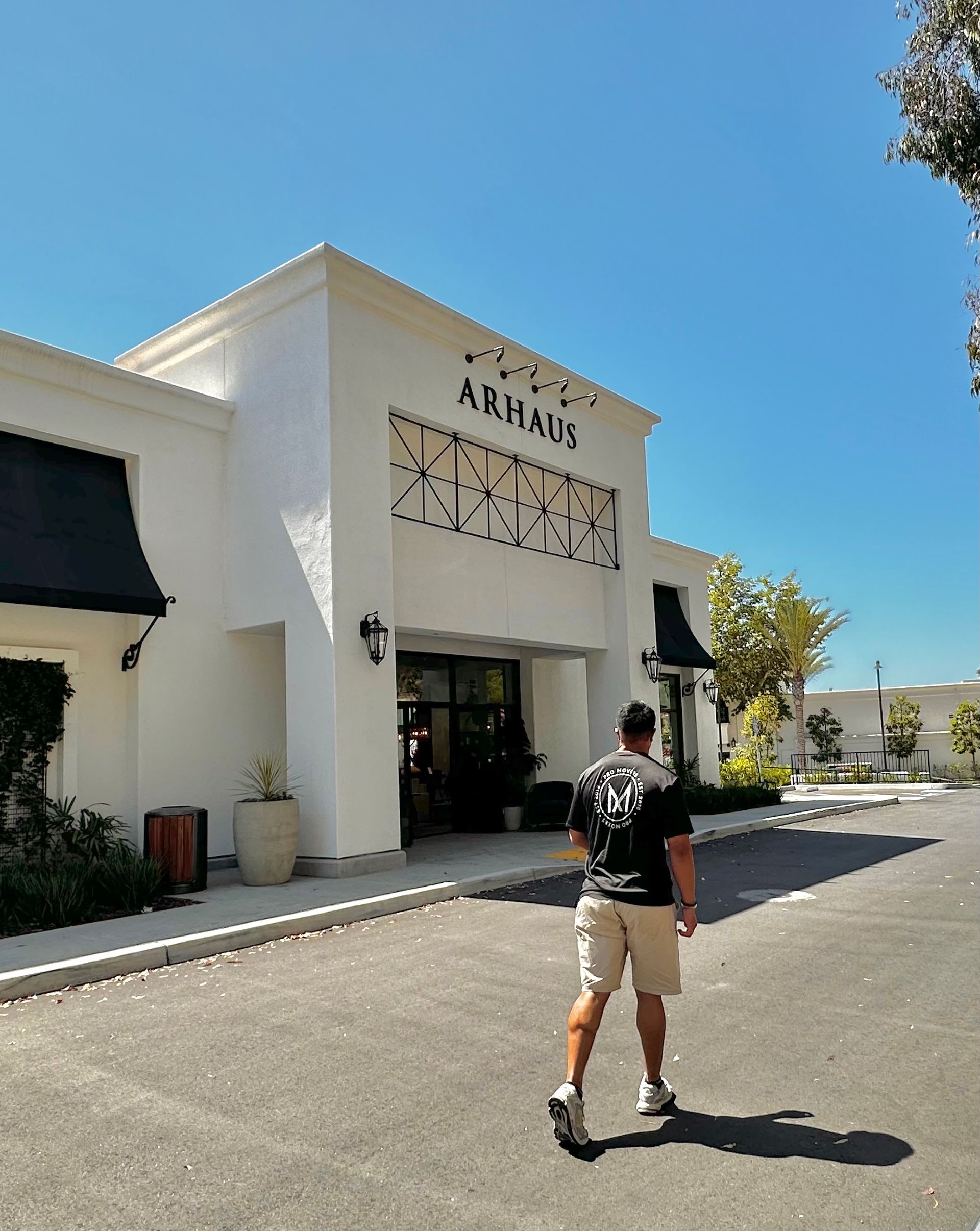 A man is walking in front of a building that says arkham