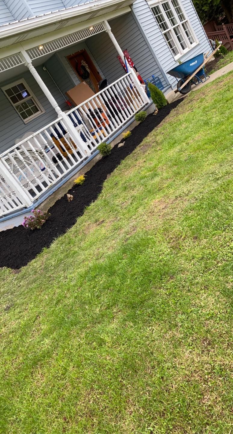 A house with a porch and a large lawn in front of it.