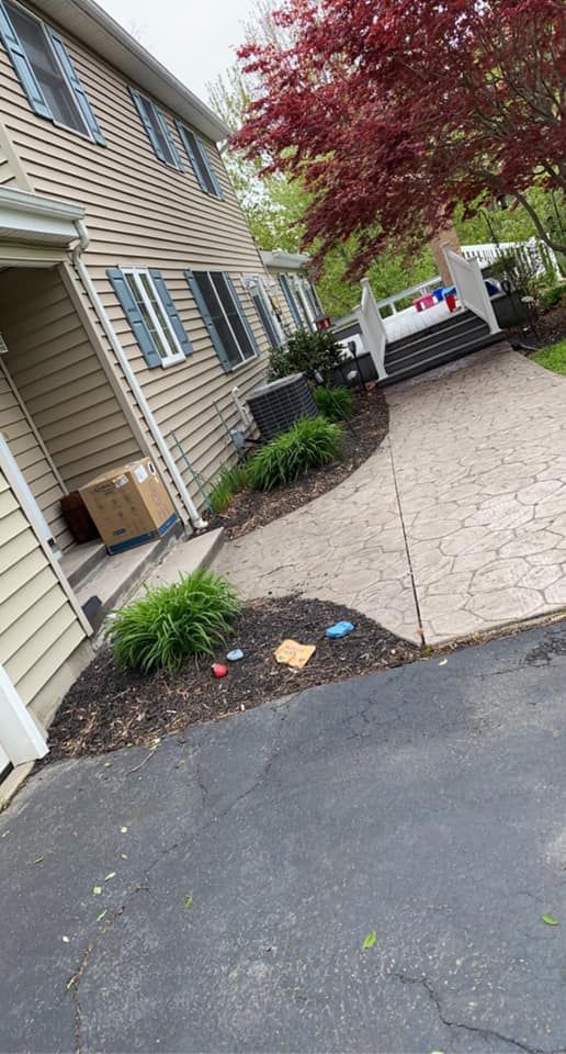 A house with a walkway leading to it and a box on the porch.