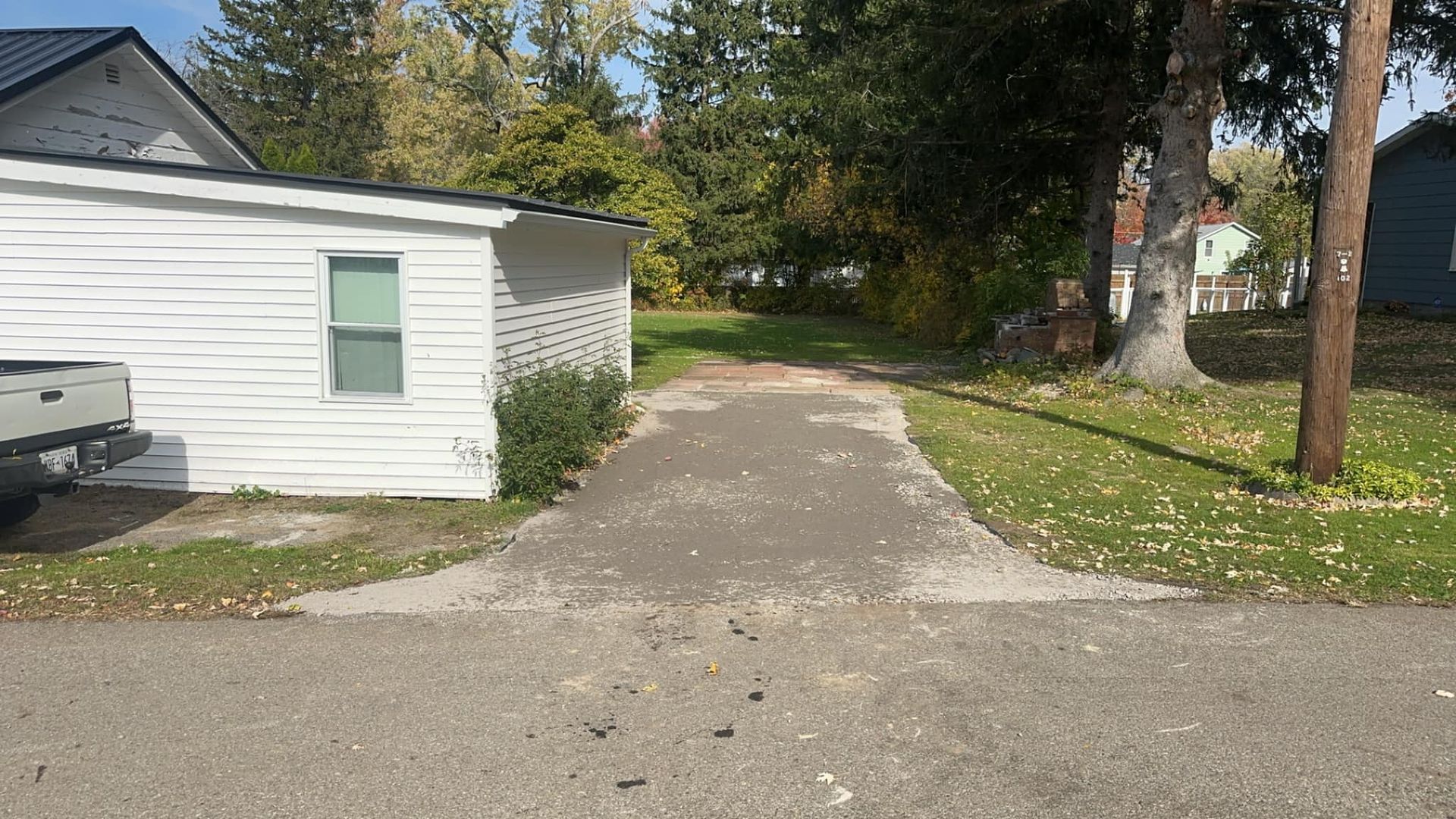 A truck is parked on the side of the road next to a house.