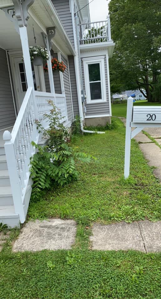 A house with a white porch and a white mailbox in front of it.