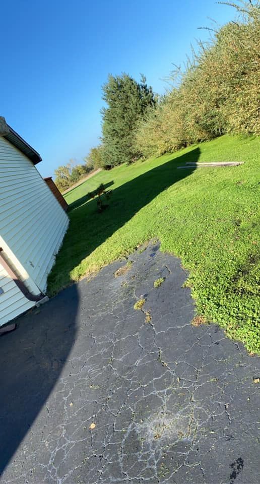 A person is walking down a driveway next to a house.