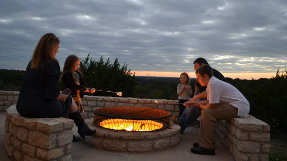 A group of people are sitting around a fire pit.