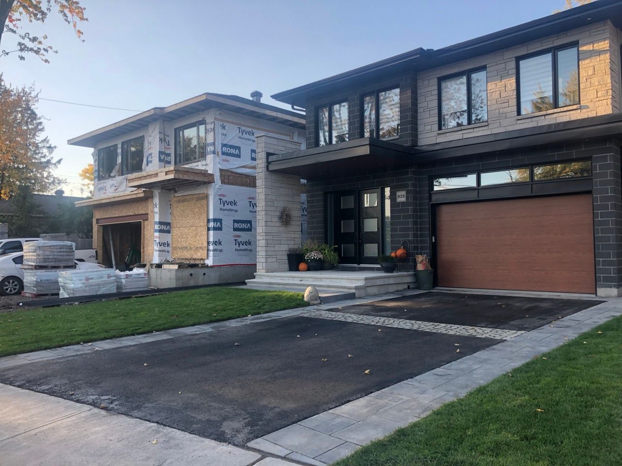 Maisons à deux étages : l'une en construction, présentant une ossature en bois