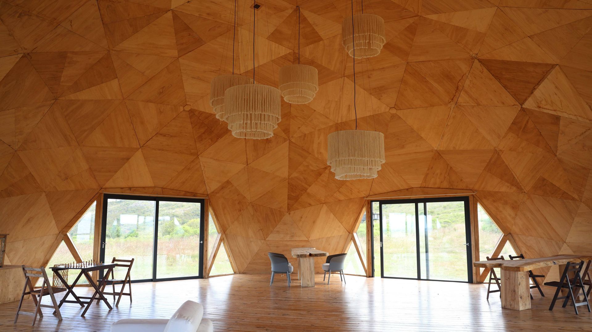 Una gran cúpula de madera con mesas y sillas en su interior.