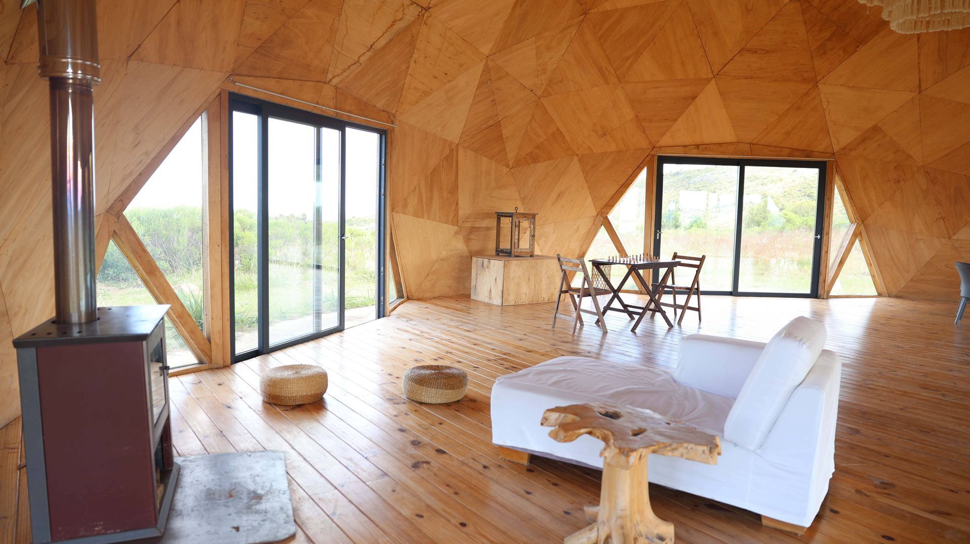 Una sala de estar con sofá, mesa y sillas en una casa con forma de cúpula.