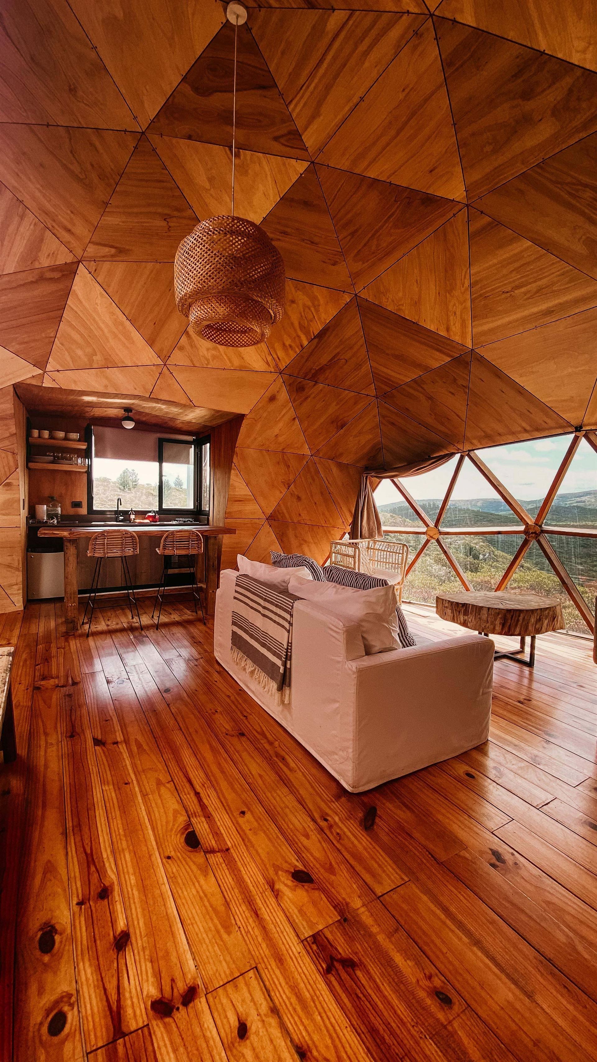 Una sala de estar con un sofá blanco y piso de madera.