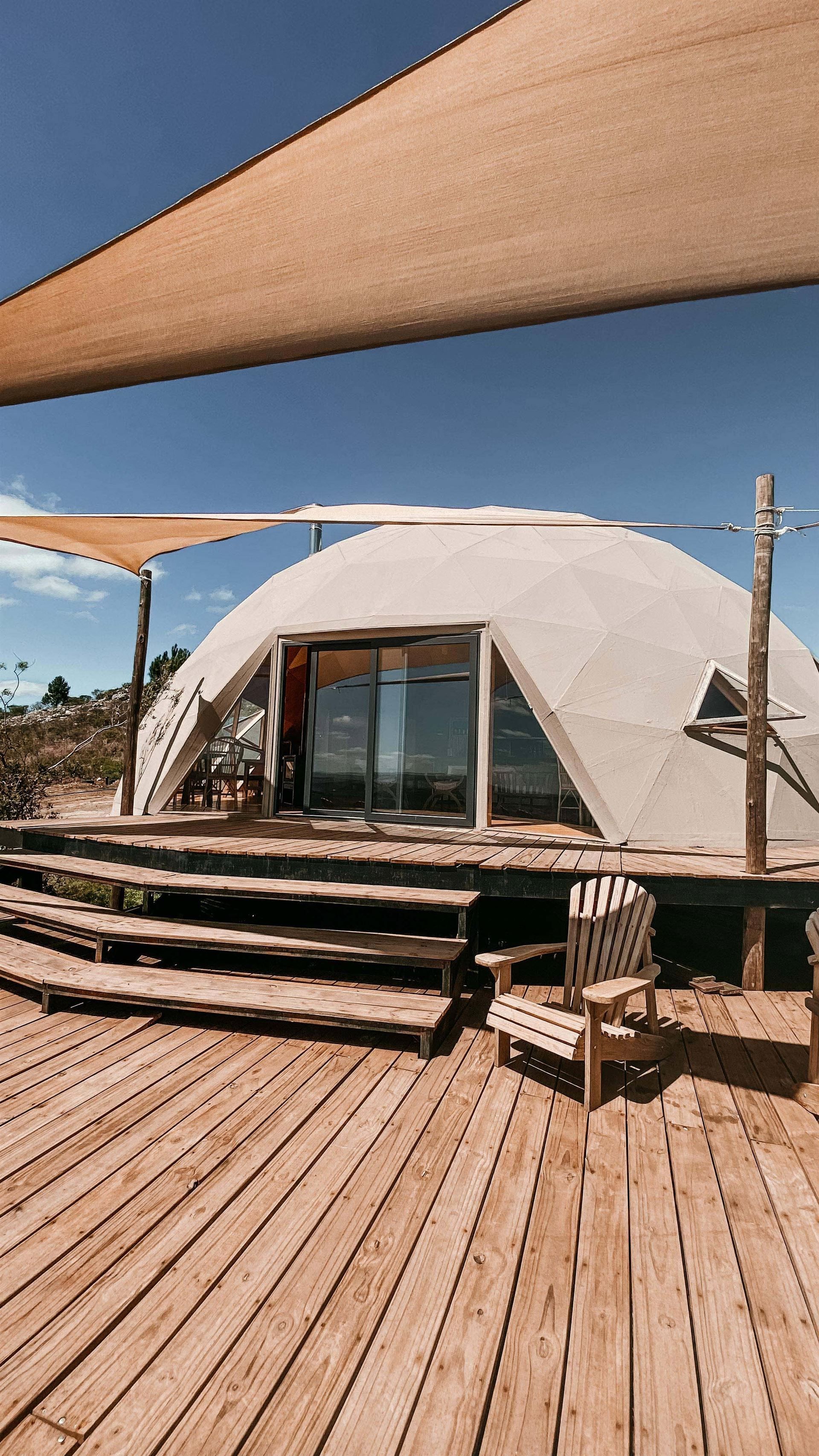 Una tienda de campaña tipo cúpula se encuentra encima de una plataforma de madera.