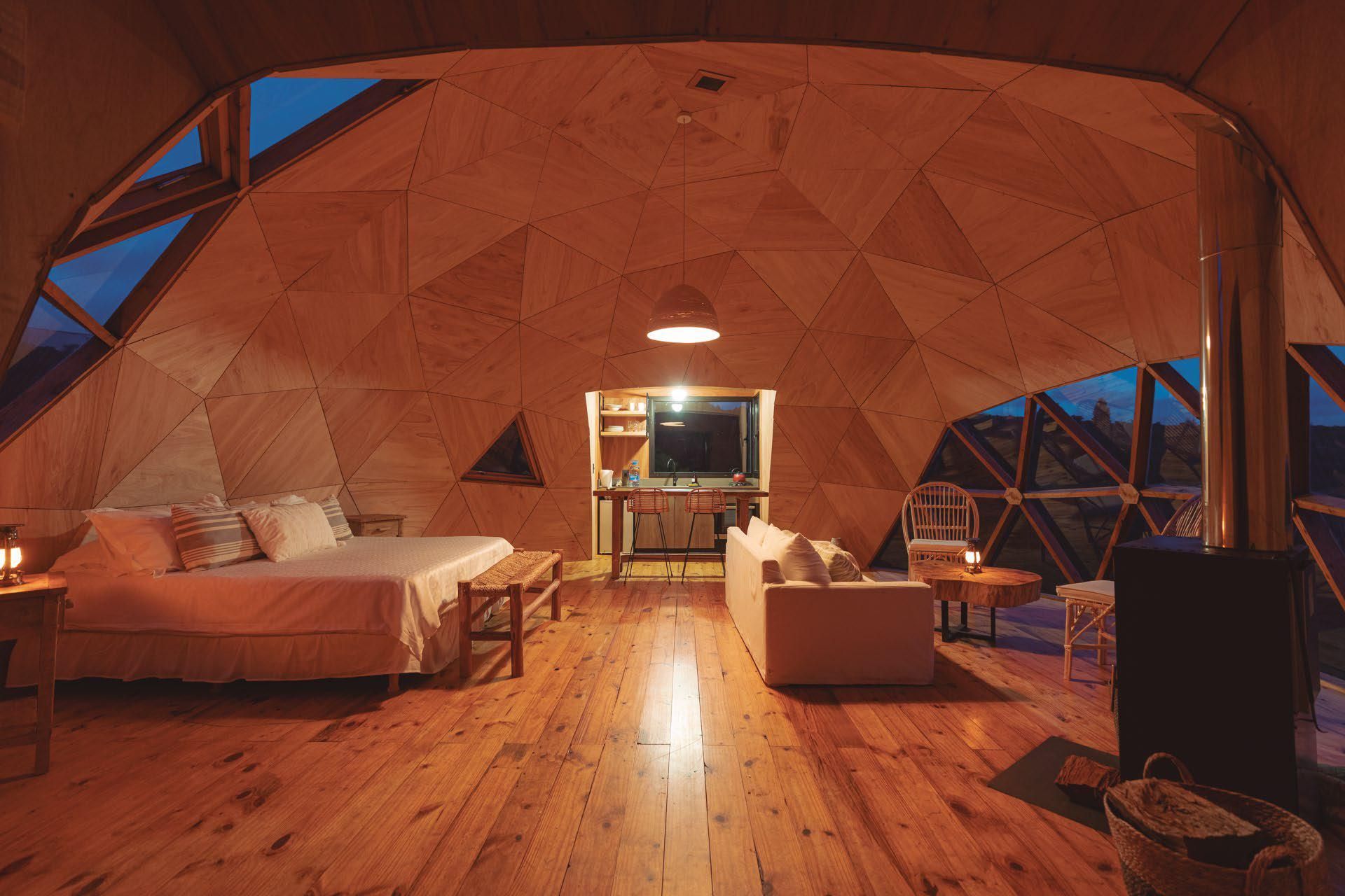 Una habitación en forma de cúpula con cama, sofá y televisión.