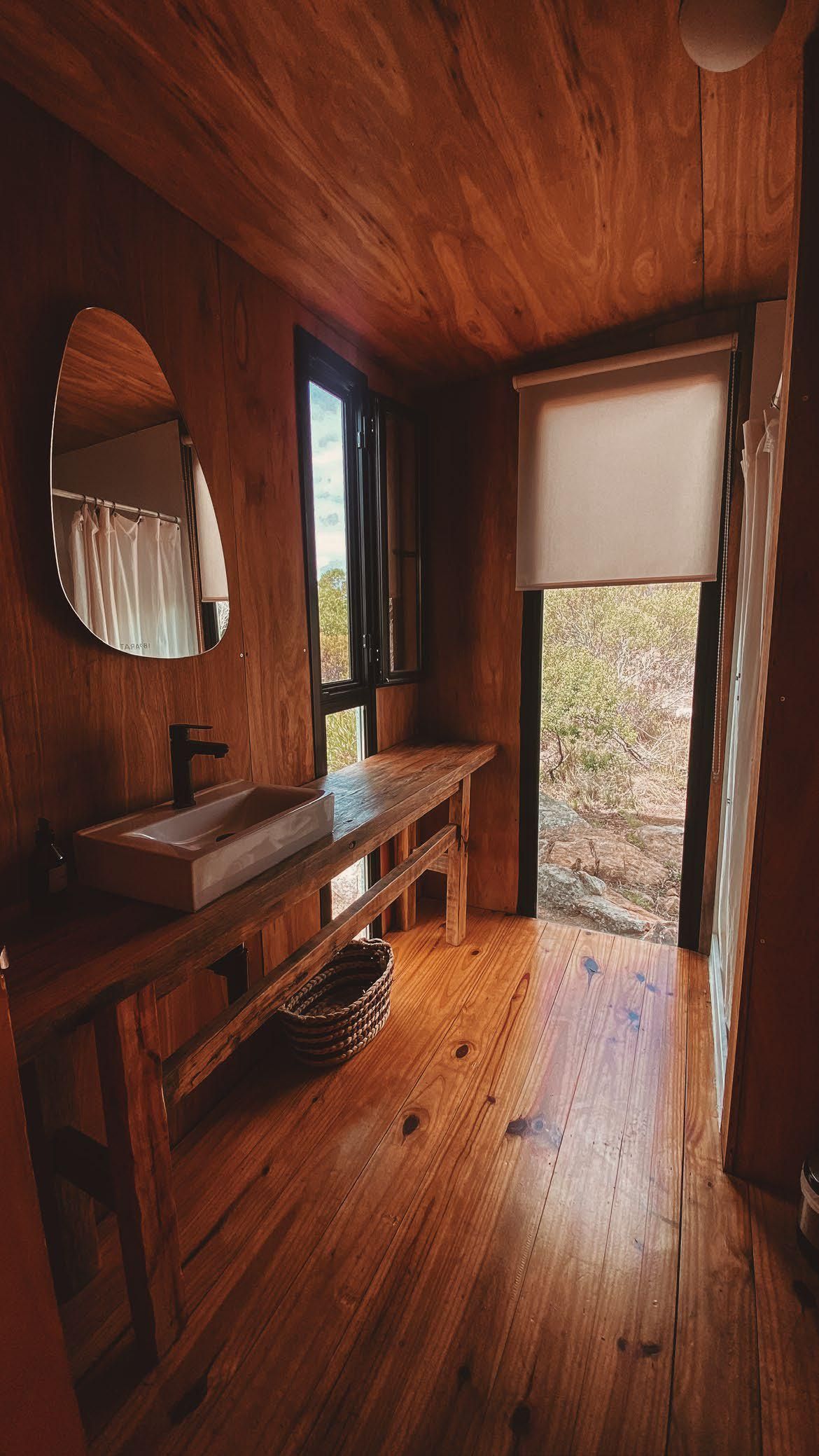 Un baño con lavabo, espejo y ventana.