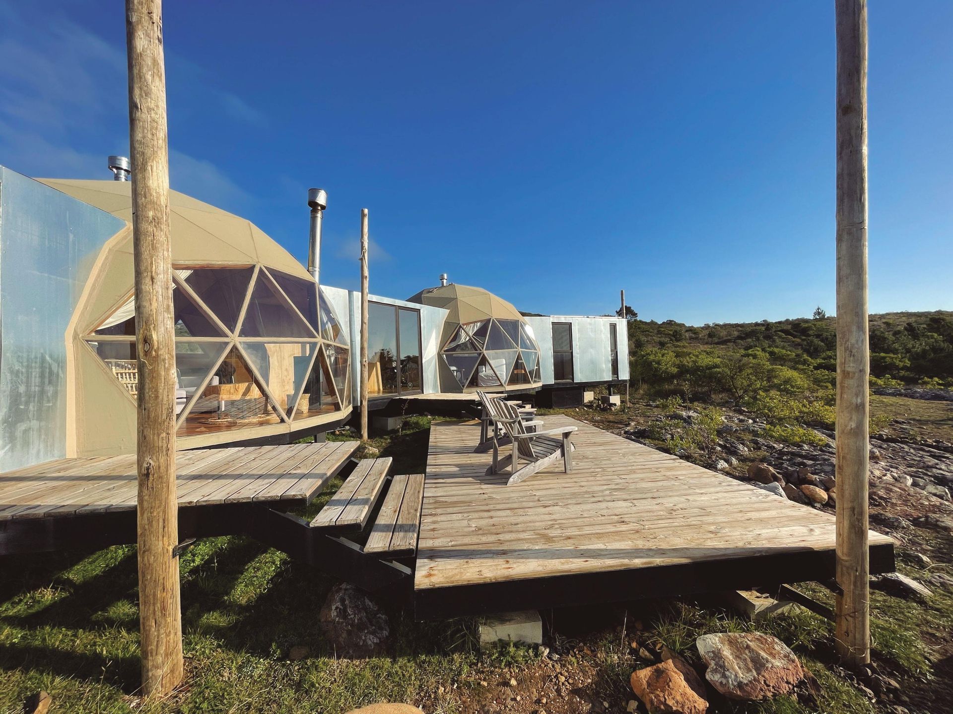 Una casa domo con una plataforma de madera frente a ella.