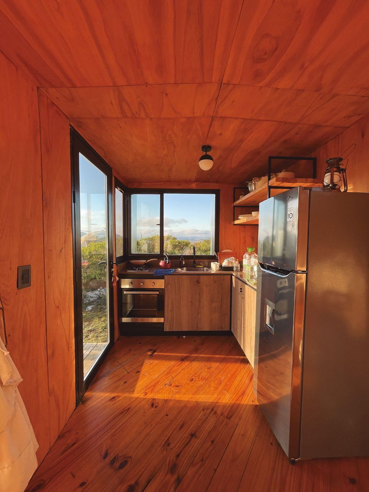 Una cocina con gabinetes de madera y refrigerador de acero inoxidable