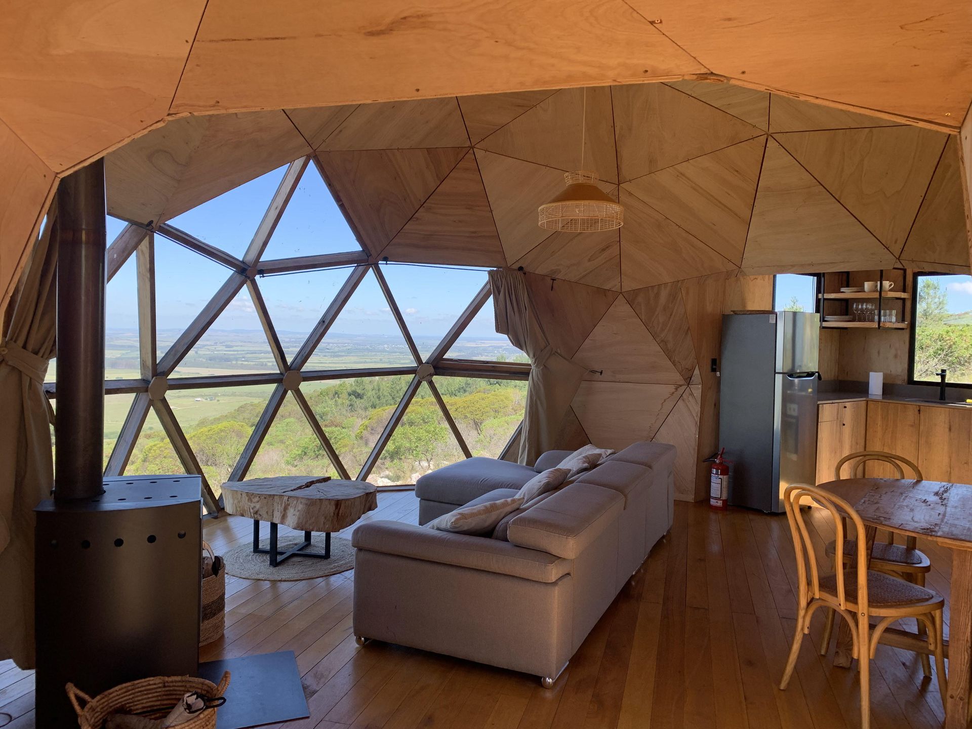 Una sala de estar con sofá, mesa y sillas en una casa con forma de cúpula.