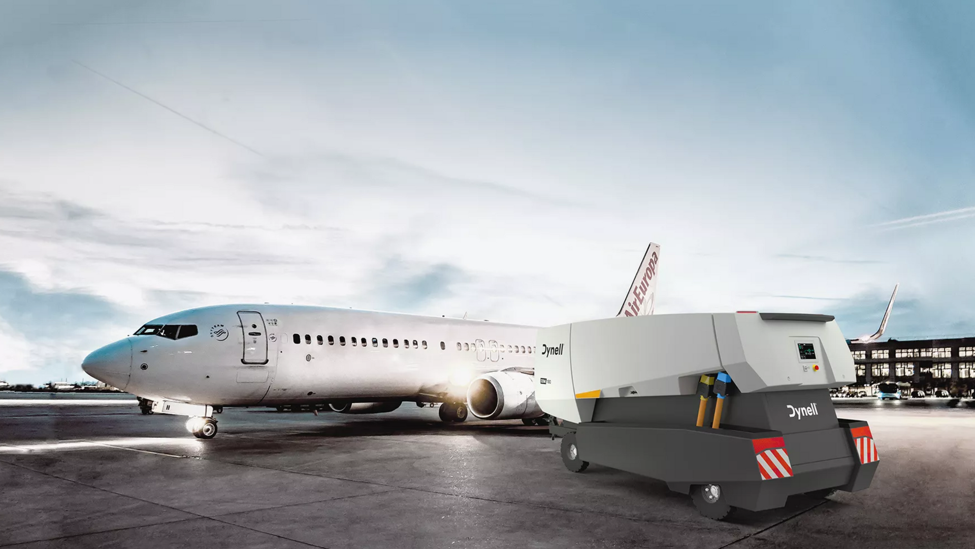 Auf einem Flughafen wird ein Flugzeug von einem Anhänger gezogen.