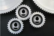 Three gears are connected to each other on a black surface.